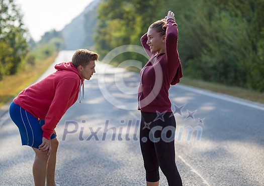 young couple enjoying in a healthy lifestyle while warming up and stretching before running on a country road, exercise and fitness concept young couple enjoying in a healthy lifestyle while warming up and stretching before running on a country road, exercise and fitness concept