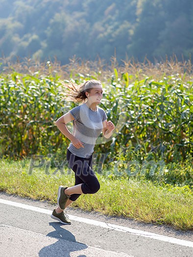young woman enjoying in a healthy lifestyle while jogging along a country road, exercise and fitness concept young woman enjoying in a healthy lifestyle while jogging along a country road, exercise and fitness concept
