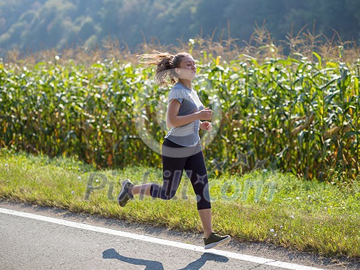 young woman enjoying in a healthy lifestyle while jogging along a country road, exercise and fitness concept young woman enjoying in a healthy lifestyle while jogging along a country road, exercise and fitness concept