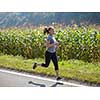 young woman enjoying in a healthy lifestyle while jogging along a country road, exercise and fitness concept