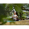 healthy woman relaxing while meditating and doing yoga exercise in the beautiful nature on the bank of the river