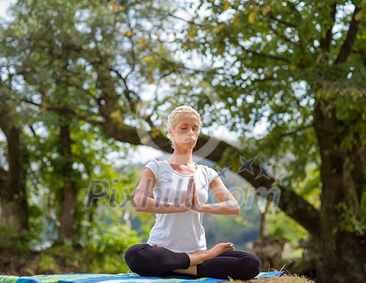 healthy woman relaxing while meditating and doing yoga exercise in the beautiful nature on the bank of the river healthy woman relaxing while meditating and doing yoga exercise in the beautiful nature on the bank of the river