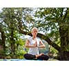 healthy woman relaxing while meditating and doing yoga exercise in the beautiful nature on the bank of the river