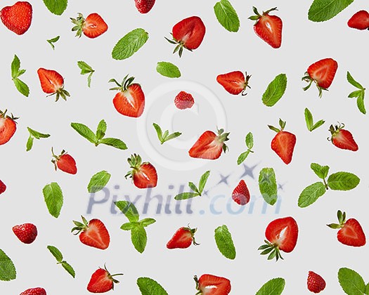 Pattern of fresh halves of ripe strawberries and green mint leaves on a gray background, flat lay Pattern of fresh halves of ripe strawberries and green mint leaves on a gray background, flat lay