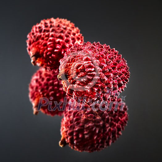 Unusual pink Lychee isolated on a black glossy background with reflection. Tropical Fruit Unusual pink Lychee isolated on a black glossy background with reflection. Tropical Fruit