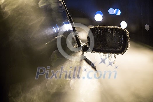 Frozen ice-locked rearview mirror and wiper of the car with icicles ice and frost. Severe winter weather dangerous road conditions concept. Frozen ice-locked rearview mirror and wiper of the car with icicles ice and frost. Severe winter weather dangerous road conditions concept.
