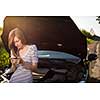 Pretty, young woman calling the roadside service/assistance after her car has broken down