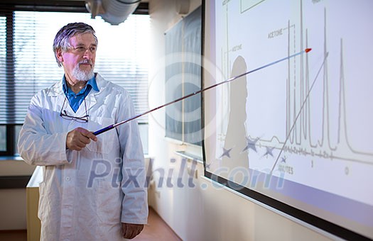 Senior chemistry professor giving a lecture in front of classroom full of students (shallow DOF; color toned image) Senior chemistry professor giving a lecture in front of classroom full of students (shallow DOF; color toned image)