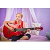 Teenage girl with her guitar in her lovely room