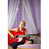 Teenage girl with her guitar in her lovely room