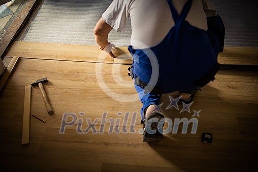 DIY, repair, building and home concept - close up of male hands lying parquet floor board/laminate flooring (shallow DOF; color toned image) DIY, repair, building and home concept - close up of male hands lying parquet floor board/laminate flooring (shallow DOF; color toned image)
