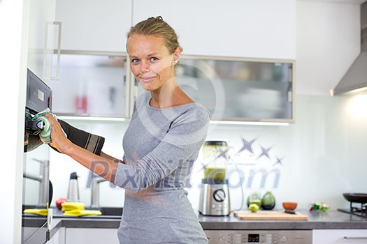 Pretty, young woman cooking in her modern kitchen Pretty, young woman cooking in her modern kitchen