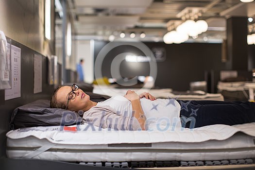 Pretty, young woman choosing the right furniture for her apartment in a modern home furnishings store (color toned image; shallow DOF) Pretty, young woman choosing the right furniture for her apartment in a modern home furnishings store (color toned image; shallow DOF)