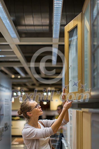 Pretty, young woman choosing the right furniture for her apartment in a modern home furnishings store (color toned image; shallow DOF) Pretty, young woman choosing the right furniture for her apartment in a modern home furnishings store (color toned image; shallow DOF)