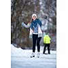 Young woman ice skating outdoors on a pond on a freezing winter day (color toned image; motion blurred image)