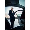 Woman driving a car - female driver at a wheel of a modern car, looking happy, smiling with a relaxed smile (shallow DOF; color toned image)