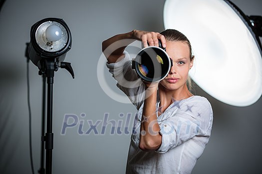Pretty, female photographer with digital camera - DSLR and a huge telephoto lens (color toned image; shallow DOF) Pretty, female photographer with digital camera - DSLR and a huge telephoto lens (color toned image; shallow DOF)