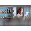 Portrait of a female researcher doing research in a biochemistry lab (shallow DOF; color toned image)