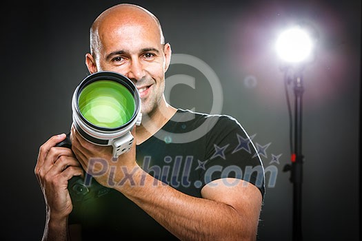 Young, pro male photographer in his studio during a photo shoot (color toned image; shallow DOF) Young, pro male photographer in his studio during a photo shoot (color toned image; shallow DOF)