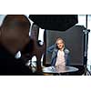 Teenage fashion model being shot by a photographer in a studio