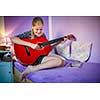 Teenage girl with her guitar in her lovely room