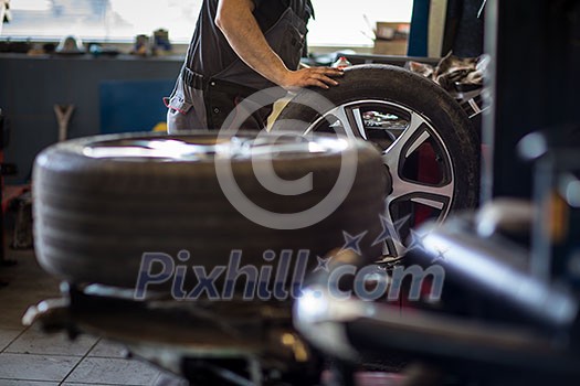 Wheel balancing or repair and change car tire at auto service garage or workshop by mechanic Wheel balancing or repair and change car tire at auto service garage or workshop by mechanic