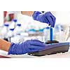 Hands of a female researcher doing research in a lab (shallow DOF; color toned image)