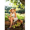 Pretty, young woman gardening in her garden - harvesting organic apples - looking very happy with the results