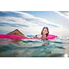 Pretty, young woman enjoying a day at the beach, relaxing on inflatable mattress