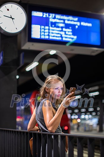 Pretty, young female commuter waiting for her daily train in a modern trainstation, using her cellphone while waiting (color toned image) Pretty, young female commuter waiting for her daily train in a modern trainstation, using her cellphone while waiting (color toned image)