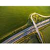 Aerial view of a highway amid fields with cars on it