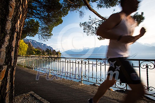 Fit man runnig by a lake (motion blurred image; color toned) Fit man runnig by a lake (motion blurred image; color toned)