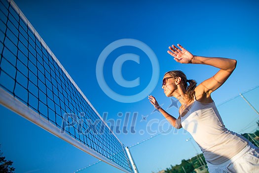 Beach Volleyball Game - Pretty, young woman playing volleyball outdoors Beach Volleyball Game - Pretty, young woman playing volleyball outdoors