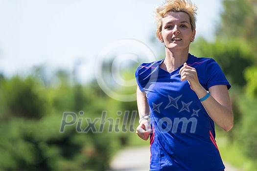 young sporty female runner training for marathon running at beautiful tropical park in the sunny morning young sporty female runner training for marathon running at beautiful tropical park in the sunny morning