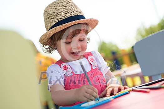 cute little girl cheerfully spending time using pencil crayons while drawing a colorful pictures in the outside playschool cute little girl cheerfully spending time using pencil crayons while drawing a colorful pictures in the outside playschool