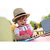 cute little girl cheerfully spending time using pencil crayons while drawing a colorful pictures in the outside playschool