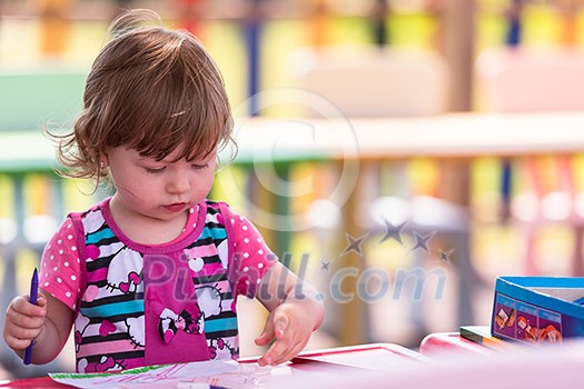 cute little girl cheerfully spending time using pencil crayons while drawing a colorful pictures in the outside playschool cute little girl cheerfully spending time using pencil crayons while drawing a colorful pictures in the outside playschool