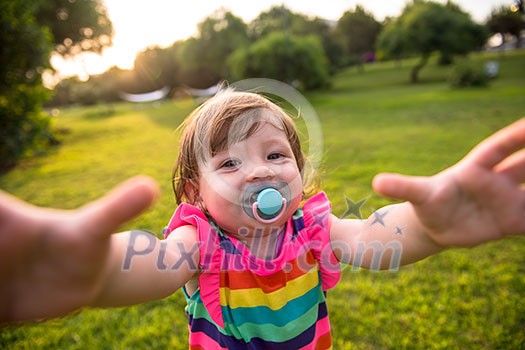 playful cute little girl cheerfully spending time while running in the spacious backyard on the grass playful cute little girl cheerfully spending time while running in the spacious backyard on the grass