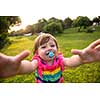 playful cute little girl cheerfully spending time while running in the spacious backyard on the grass