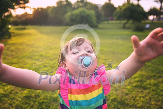 playful cute little girl cheerfully spending time while running in the spacious backyard on the grass playful cute little girl cheerfully spending time while running in the spacious backyard on the grass
