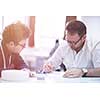 Group of a young business people brainstorming and discussing business plan on meeting at startup office interior