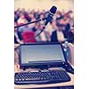 laptop computer and microphone at podium on business seminar education  in modern conference room