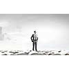 Young confident businessman with arms on waist standing on pile of old books