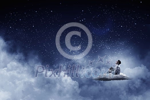 Businessman in suit sitting on cloud in isolation and looking at moon Businessman in suit sitting on cloud in isolation and looking at moon
