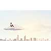 Depressed young businessman sitting alone on cloud high in sky