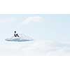 Depressed young businessman sitting alone on cloud high in sky