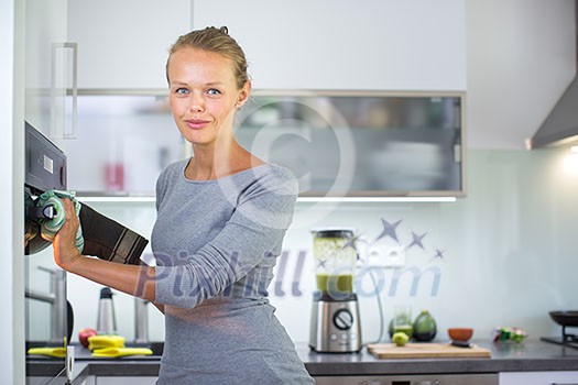 Pretty, young woman cooking in her modern kitchen Pretty, young woman cooking in her modern kitchen