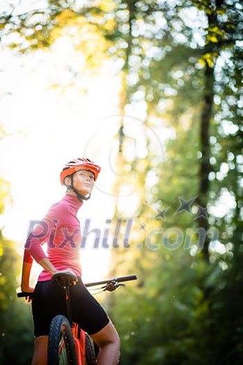 Pretty, young woman biking on a mountain bike enjoying healthy active lifestyle outdoors in summer (shallow DOF) Pretty, young woman biking on a mountain bike enjoying healthy active lifestyle outdoors in summer (shallow DOF)