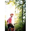 Pretty, young woman biking on a mountain bike enjoying healthy active lifestyle outdoors in summer (shallow DOF)