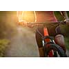 Pretty, young woman biking on a mountain bike enjoying healthy active lifestyle outdoors in summer (shallow DOF)